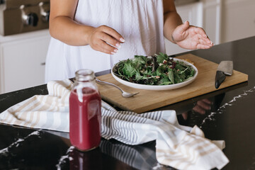 Woman preparing salad in luxury kitchen
