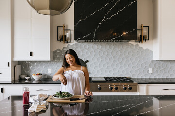 Pregnant woman preparing healthy salad in luxury kitchen