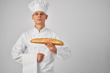 a man with a loaf in his hands in chef's clothes cooking food baker