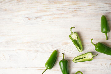 Green jalapeno peppers wooden background, place for text. Top view. - obrazy, fototapety, plakaty