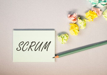 Scrum word on paper note on office desk, top view. Concept of methods in management.