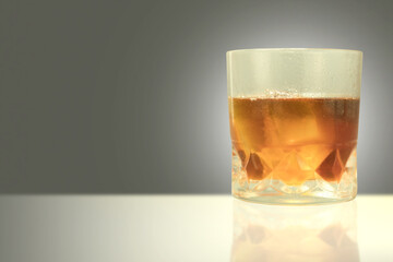 Misted glass with drops of water and whiskey with ice