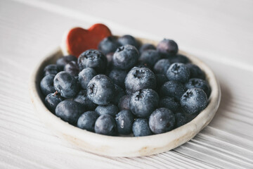 blueberries in a small ceramic bowl with a red heart decor