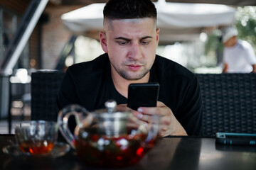 Young man watching smartphone  in cafe . Freelance concept