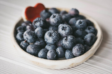 blueberries in a small ceramic bowl with a red heart decor