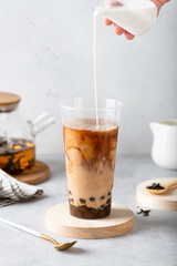 Making milk bubble tea with tapioca in a plastic cup, selective focus