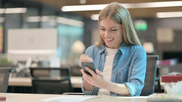 Successful Young Woman Celebrating on Smartphone