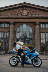 Fototapeta na wymiar Seductive girl posing on motorcycle smoking vape outside