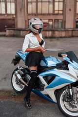 Fototapeta na wymiar Seductive woman biker posing on motorbike on country road