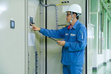 Electrical inspector engineer checking status multi meter of distribution board load panel at production line in the industrial factory