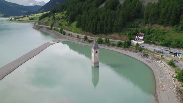 Submerged bell Tower of Curon at Graun im Vinschgau on Lake Reschen Alpine landscape aerial view, South Tyrol region Italy