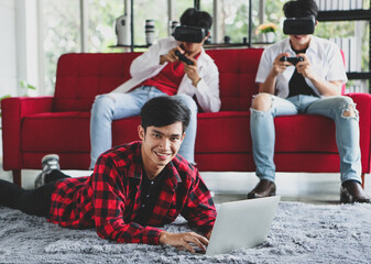 Asian man using laptop near friends