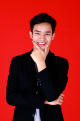 Fototapeta na wymiar Portrait asian young man smart and handsome standing and posing look at camera and smile on face. Shoot in studio with red background and copy space use to be design advertising banner