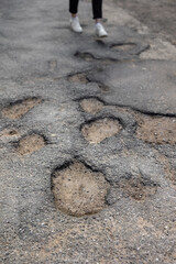 Broken pavement, potholes in the asphalt, large and deep holes or potholes, poor work of road services or improper technology of laying asphalt in cities. large potholes are unsightly and dangerous