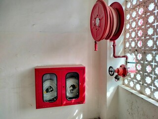 Mathura, Uttar Pradesh India- July 25 2021: Water pipe and Hose reel placed in the corner of a building to prevent massive fire emergency.