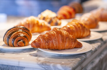 Several croissants are placed on the marble table before serving