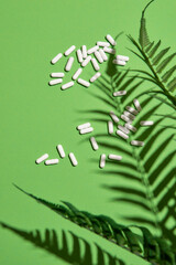 Many white capsule pills on a colorful background. Health supplements and medicines