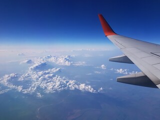 Obraz premium Airplane wing in the blue sky