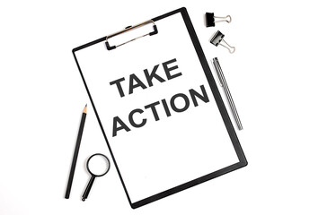 On a white background magnifier, a pen and a sheet of paper with the text TAKE ACTION . Business concept