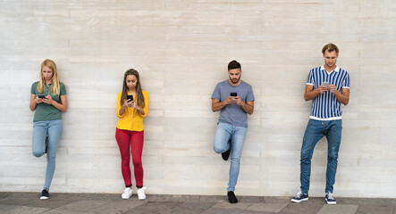 Obraz premium Young multiracial group of friends using mobile smartphone outdoor - Youth millennial lifestyle concept