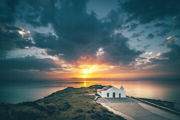 Beautiful little church by the sea in sunrise or sunset. Landscape shot in backlight with a view of...