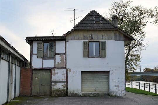Old abandoned house on the bank of river Aare in Aarburg, Switzerland. There is an analogue aerial on the roof. 