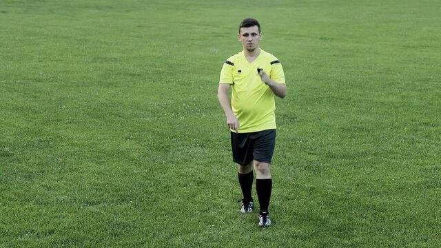 Soccer referee shows offside after watching VAR . Concept of sport, rules violation, offside.