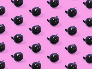 Soft children's toy fluffy black cat pattern by pink background.