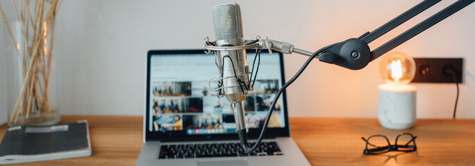 Interior of podcast room. Studio for streaming voice. Microphone, laptop, notepad and lamp on...