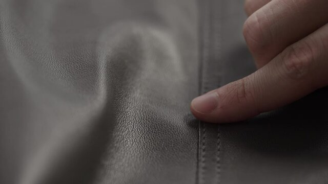 Slide shot man touching fine leather seam closeup