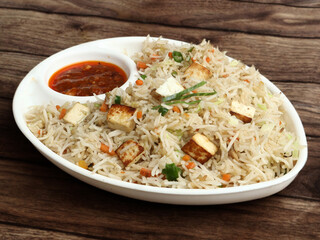 Healthy and tasty Paneer fried rice made of rice, mixed veggies and paneer, served in bowl over a...