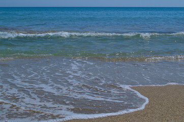 Sandy beach, beautiful sea waves and blue sky.