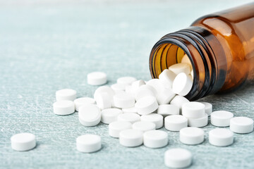 Pills spillig out of pill bottle - close-up