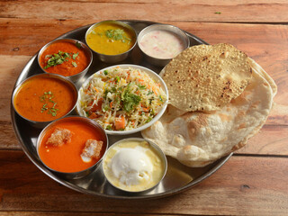 Veg Thali from an indian cuisine, food platter consists variety of veggies,soup,paneer dish, lentils,rice, sweet dish, snacks etc., selective focus