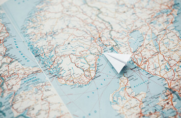 Travel concept - white paper plane on a map