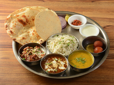 Punjabi Veg Thali from an indian cuisine, food platter consists variety of veggies, lentils, jeera rice, roti, sweet dish, curd, pickle etc., selective focus