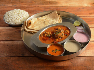 Chicken Thali from an indian cuisine, food platter consists of Chicken curry, lentils, jeera rice, curd and onions., selective focus