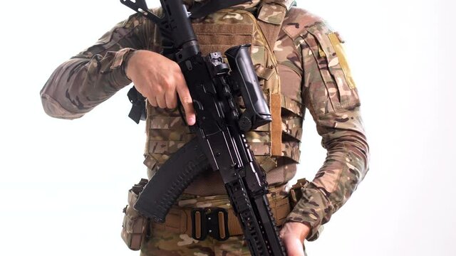 Navy SEAL soldier wearing a multicam tactical outfit at plate carrier with a combat rifle in his hands rotates 360 degrees on a white background