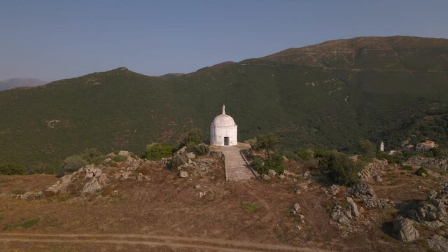 Aerial view circling a mausoleum above the village of Palasca in the Balagne region of Corsica