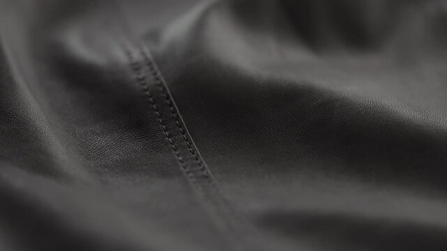 Slow motion handheld shot of soft gray brown leather closeup