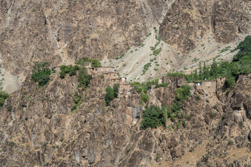 Isolated Afghan village perched on rocky cliff above Panj river, Darvaz, Gorno-Badakshan, Pamir mountain region of Tajikistan