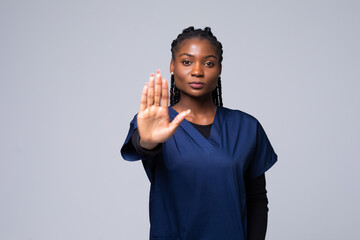 Young beautiful African American doctor woman doing stop gesture with palm of the hand. Warning...