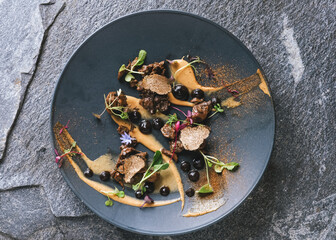 Experimental high gastronomy master piece from chef with black truffles decorated on the stone plate