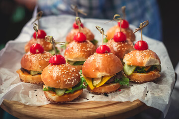 Burger mini burgers snacks on a wooden table with craft paper, beautifully decorated catering...