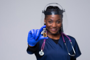 Medicine, vaccination and healthcare concept, African american female doctor or scientist in mask with syringe over grey background