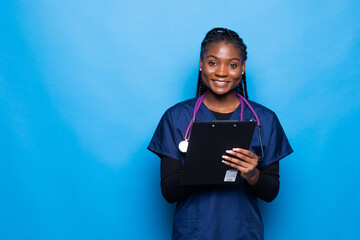 Smiling african american female doctor woman hold clipboard with medical documents isolated on blue...