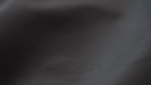Slow motion handheld shot of soft gray brown leather closeup