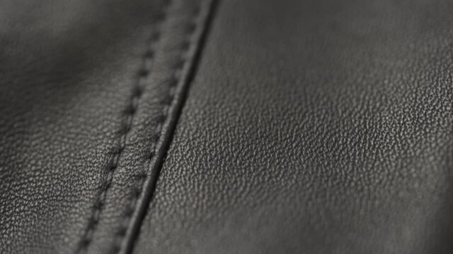 Slow motion handheld shot of soft gray brown leather closeup