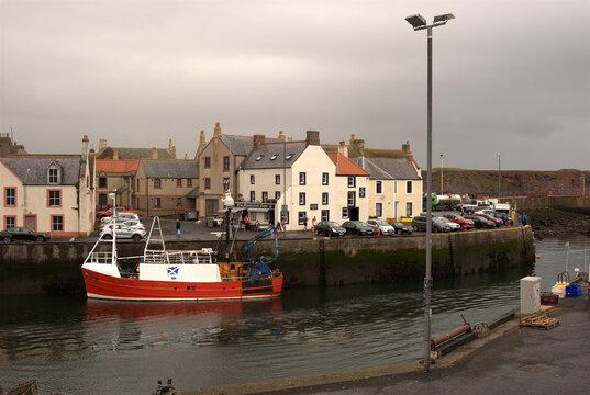 Eyemouth harbour fishing boat and town on dull day