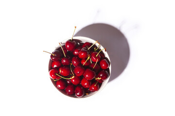 top view of a bowl full of cherries with white background. Healthy food concept.